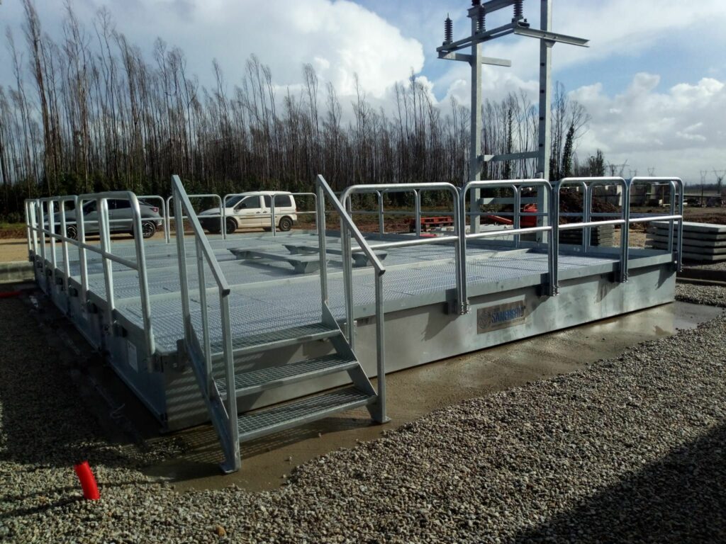 Escalera y barandilla galvanizadas alrededor de cubeto de retención modular con cubierta cortafuegos de Sanergrid